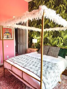 1 dormitorio con cama con dosel y pared verde en Dreaming With Dolly - Luxe Stay Near Broadway, en Nashville
