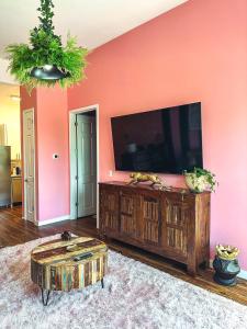 a living room with a flat screen tv on a wall at Dreaming With Dolly - Luxe Stay Near Broadway in Nashville