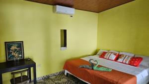 1 dormitorio con 1 cama con pared verde en El Rancho De Don Moncho Hostel 