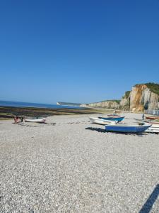 a group of boats sitting on a rocky beach at Le paradis bleu in Bosville