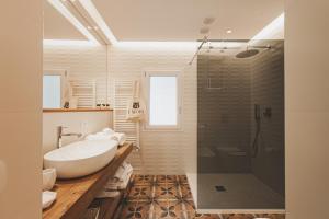 uma casa de banho branca com uma banheira e um chuveiro em I Mori Apartments em Cefalù