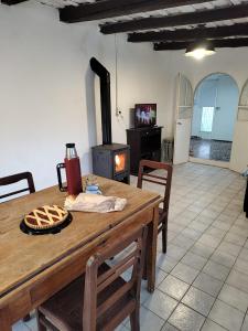 cocina con mesa de madera y estufa de leña en Cómoda casa en El Volcan en San Luis