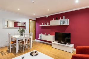 a living room with a red wall at BNBHolder Apartamentos en Sol Confort 6 in Madrid