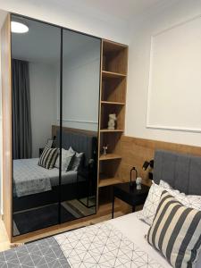 sypialnia z łóżkiem i szklaną ścianą w obiekcie Apartments Mrdak w Barze