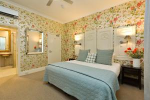 1 dormitorio con 1 cama con papel pintado con motivos florales en Twelve on Albert, en Beechworth