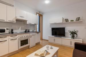 cocina grande con armarios blancos y mesa en BNBHolder Apartamentos en Sol Confort 3 en Madrid