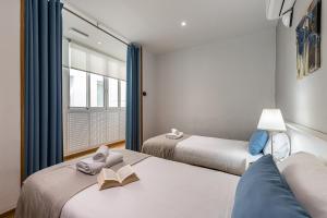 Duas camas com livros num quarto em BNBHolder Apartamentos en Sol Confort 3 em Madri