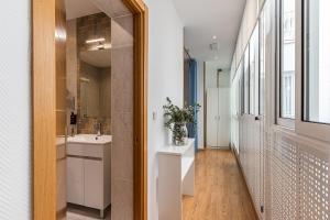 un corridoio con bagno con lavandino e specchio di BNBHolder Apartamentos en Sol Confort 3 a Madrid