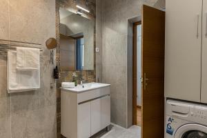 łazienka z umywalką i pralką w obiekcie Waou Apartamentos en Sol Confort 3 w Madrycie
