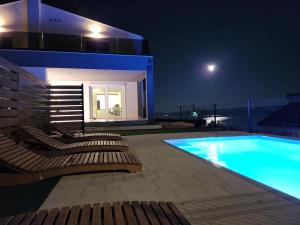 a house with a swimming pool at night at Villa M&M in Stanići