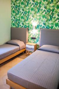 カッシーノにあるLe Colonneの緑の壁紙のドミトリールーム ベッド2台