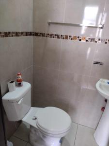ein Badezimmer mit einem weißen WC und einem Waschbecken in der Unterkunft Ideal para descansar in Ambato