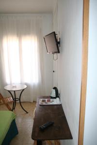 a room with a table and a tv on the wall at Hostal Juventus in Portbou