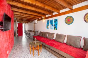 Una sala de estar con un sofá rojo y una mesa. en Villa casa blanca luxury spa con piscina privada y jacuzzi privado, en Chiclana de la Frontera