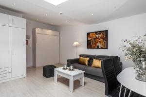 un soggiorno con divano e tavolo di BNBHolder Apartamentos en Sol Confort 1 a Madrid