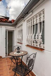 eine Terrasse mit einem Tisch und Stühlen auf dem Balkon in der Unterkunft BNBHolder Apartamentos en Sol Confort 1 in Madrid