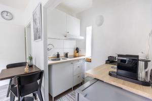 uma cozinha com armários brancos e uma mesa com um micro-ondas em Perfekt für 2! Wifi/ Netflix em Duisburg