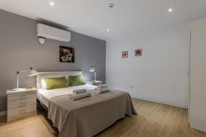 sypialnia z łóżkiem z zielonymi poduszkami w obiekcie BNBHolder Apartamentos en Sol Confort 2 w Madrycie