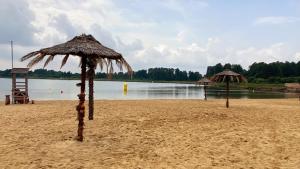 加沃林的住宿－Siedlisko pod Kasztanem，海滩上两把带水的草伞