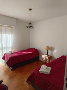 1 dormitorio con 2 camas con sábanas rojas en Departamento Centro en Bahía Blanca