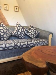 un sofá con almohadas y una mesa de madera en Cabaña para Dos - Tinaja Privada e Hidromasaje - Mirador Llaima, en Curacautín