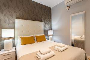 1 dormitorio con 1 cama blanca grande con almohadas amarillas en BNBHolder Apartamentos en Sol Superior 1 en Madrid