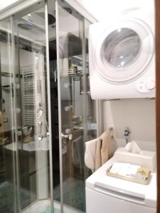 een badkamer met een douche en een wasmachine bij I Tre Oleandri Varenna in Varenna