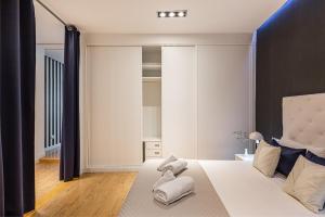 um quarto com uma grande cama branca com cortinas pretas em BNBHolder Apartamentos en Sol Deluxe 3 em Madrid