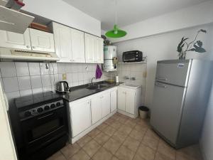 uma cozinha com armários brancos e um frigorífico em Departamento en Mendoza Capital em Mendoza