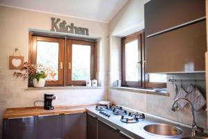 uma cozinha com um lavatório e uma bancada em La casa al Lago em Trevignano Romano