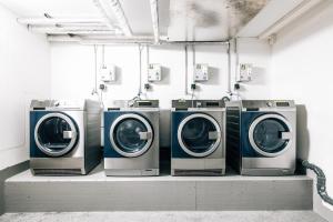una fila de lavadoras y secadoras en una habitación en City - Travel & Living - Appartement en Bielefeld