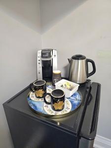 a table with three cups and a coffee pot on it at Lilen's Home in Toronto