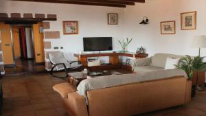 a living room with a couch and a tv at Casa Daniela en la Asomada in La Asomada