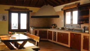 a kitchen with a wooden table and a dining room at Casa Daniela en la Asomada in La Asomada