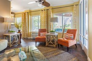 a living room with orange chairs and a glass table at Best Western Plus Wilmington/Carolina Beach in Wilmington