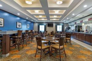 a dining room with tables and chairs and a bar at Best Western Plus Longhorn Inn & Suites in Luling
