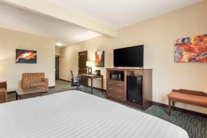 a hotel room with a bed and a flat screen tv at Best Western Plus Longhorn Inn & Suites in Luling
