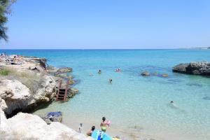 a group of people in the water at a beach at La Finestra su Santa Lucia in Monopoli