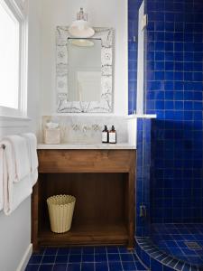 a blue tiled bathroom with a sink and a mirror at Farmhouse Paso in Paso Robles