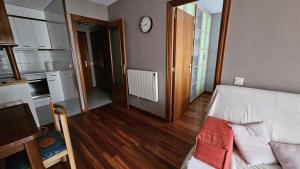 sala de estar con cama y reloj en la pared en Apartamento Tramuntana, en Canfranc-Estación