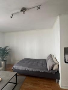 uma cama num quarto com uma parede branca em 35m2 apartment in central oslo em Oslo