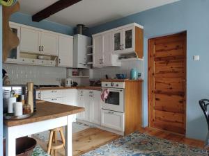a kitchen with white cabinets and a wooden counter top at Trzemcha in Tuchów