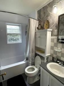 La salle de bains blanche est pourvue de toilettes et d'un lavabo. dans l'établissement The Bourbon & Horse Country EpiCenter, à Frankfort
