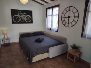 1 dormitorio con 1 cama y reloj en la pared en Chill Out Cabanon Coeur Calanques en Marsella