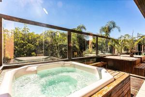 a bath tub sitting on top of a deck at Resort pé na areia - Studios direto com proprietário JBVJR in Florianópolis