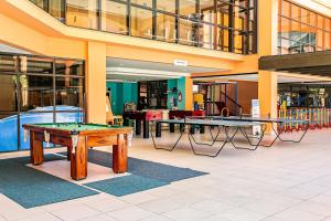 une chambre avec deux tables de ping-pong dans un bâtiment dans l'établissement Resort pé na areia - Studios direto com proprietário JBVJR, à Florianópolis