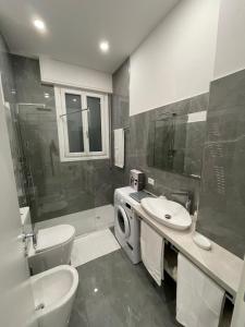 ein Badezimmer mit einem Waschbecken und einer Waschmaschine in der Unterkunft LuxuryBnBo in Bologna