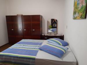 ein Schlafzimmer mit einem Bett mit zwei Kissen und einem Spiegel in der Unterkunft Casa Oma Loni in Pomerode