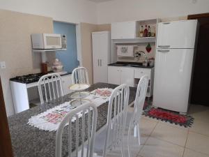 a kitchen with a table and chairs and a refrigerator at Casa Oma Loni in Pomerode