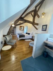 ein Schlafzimmer mit einem Bett und Stühlen im Dachgeschoss in der Unterkunft Le Clos du Q’hâtre in Cléry-Saint-André